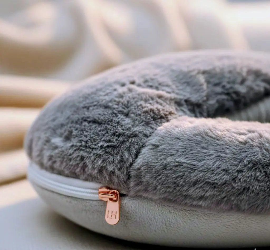 Gray Foot Heating Pad with a zipper on a blurred background